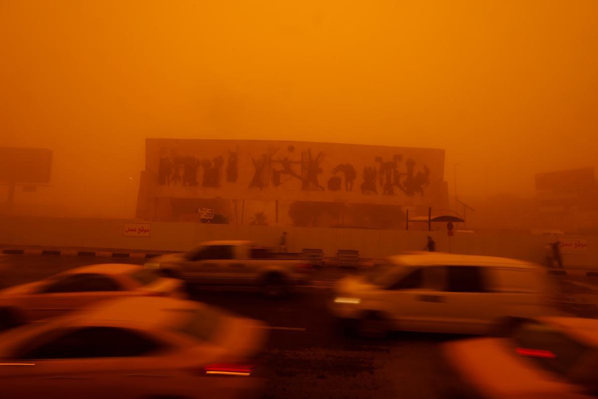 Tráfico en la plaza Tahrir de Bagdad, bajo la tormenta de arena