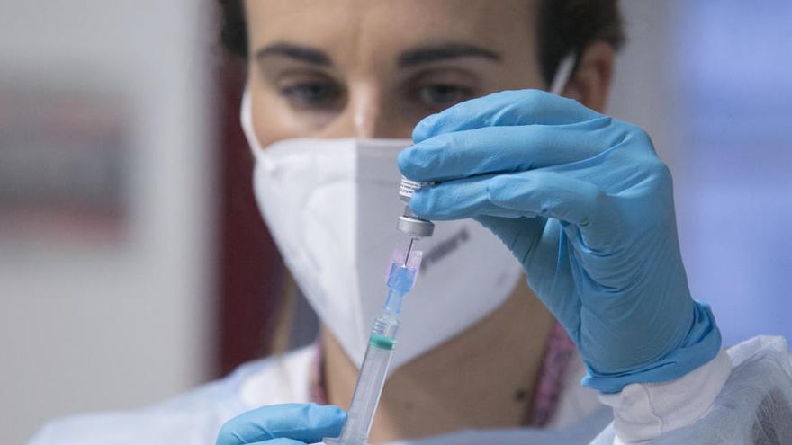 Una sanitaria prepara una vacuna de Pfizer en Gijón.