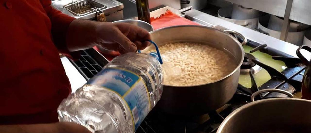 Un trabajador de un restaurante de la zona afectada cocinando con agua embotellada.