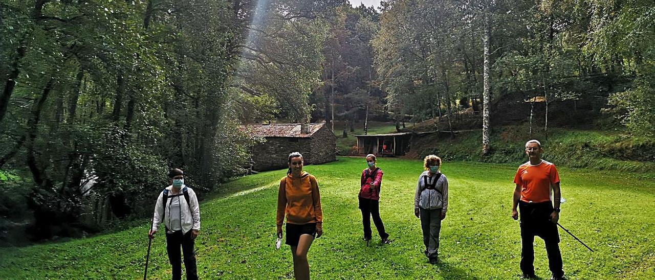 Caminantes guardando la distancia de seguridad 
delante del molino de Froiz, en la exitosa Ruta 
dos Muiños do Rego de Lamas.   | // ROTEIROS DE LALÍN