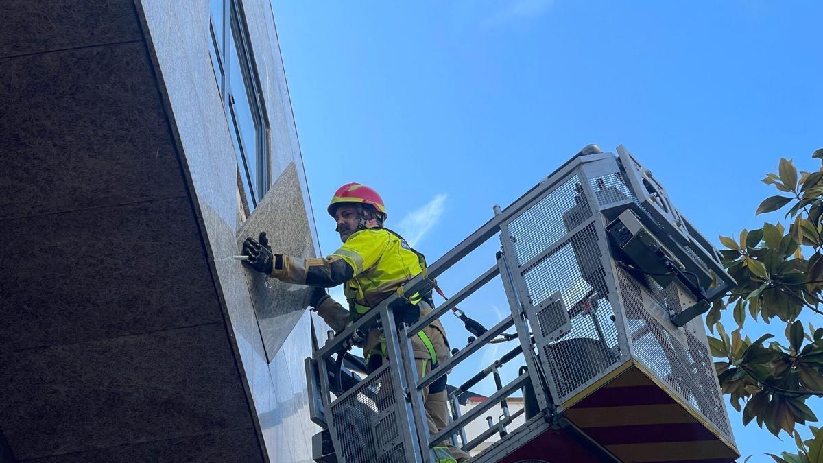 Retirada de losas en la fachada del edificio de Santa Cruz en el que se produjo el desprendimiento.