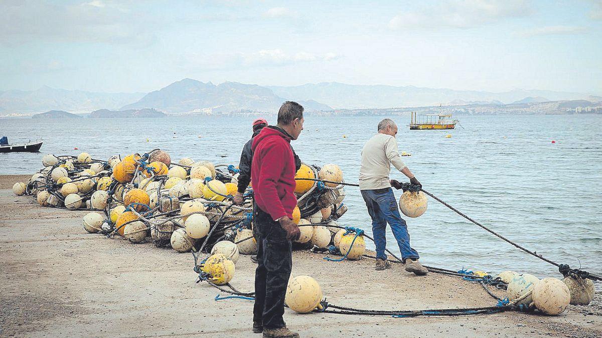 Varios pescadores realizando trabajos previos.