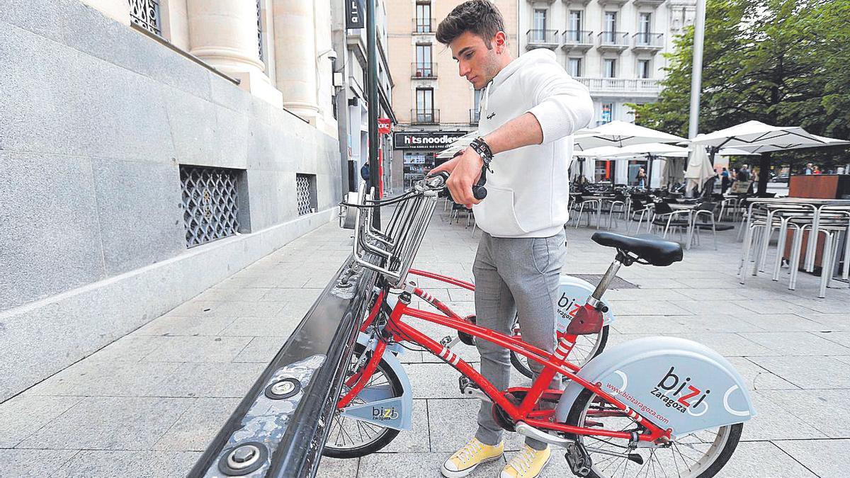 Un usuario del Bizi Zaragoza desanclando la bicicleta en la estación de plaza España.
