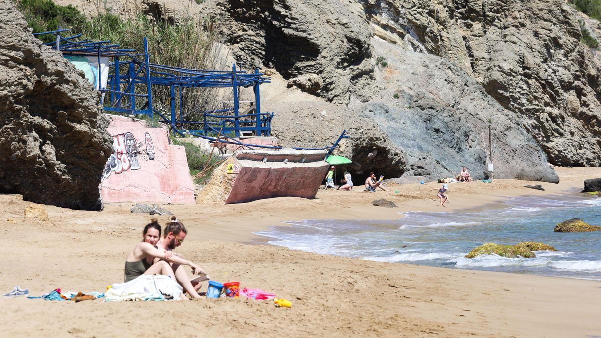 Usuarios de la playa este lunes, cerca del talud del antiguo quiosco.