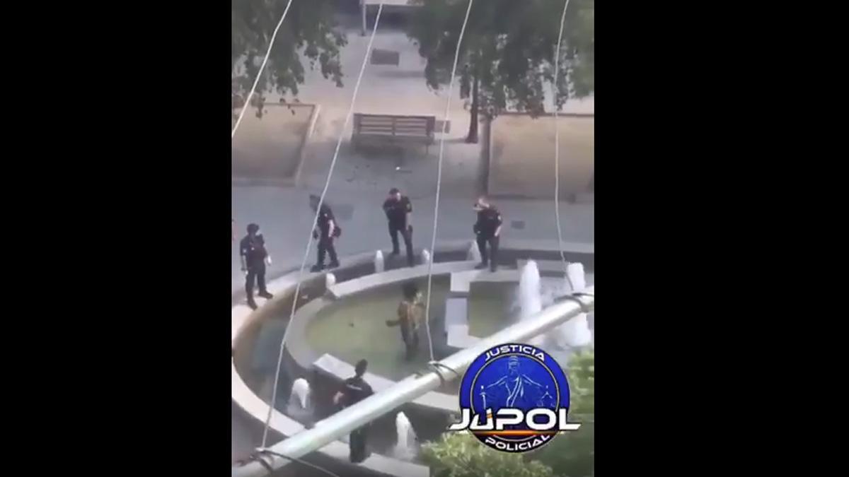 Momento en que un policía reduce a un hombre que blandía un machete dentro de una fuente en el barrio de San Cristóbal de los Ángeles, en Madrid, el miércoles pasado