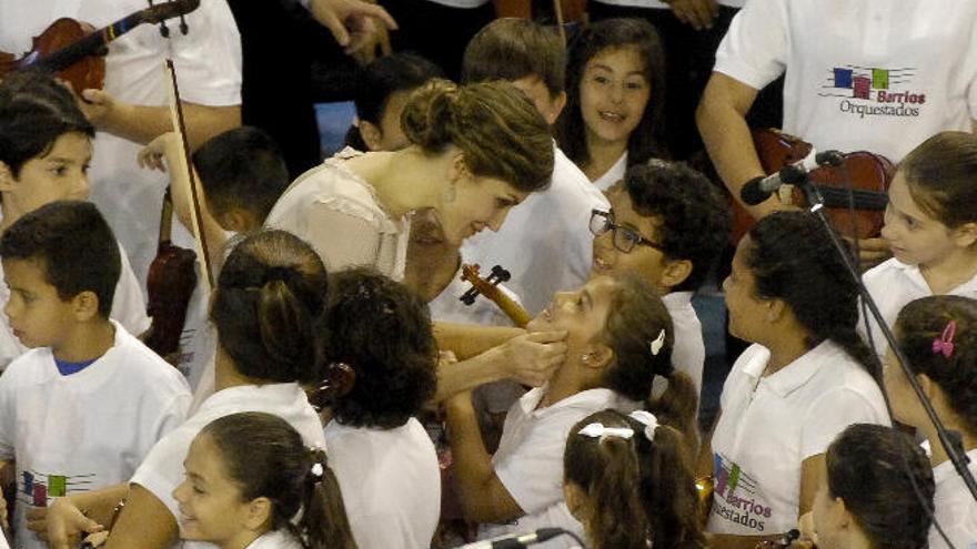 Doña Letizia saluda a una de las jóvenes violinistas de Barrios Orquestados tras el concierto ofrecido a los monarcas en el polideportivo de El Batán.