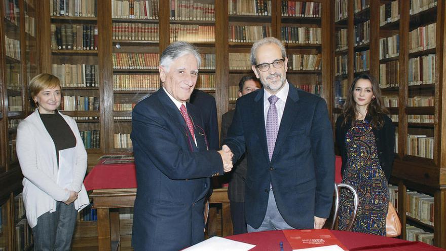 El abogado Manuel Prieto escenifica la donación con el rector de la Universidad, Daniel Hernández Ruipérez.