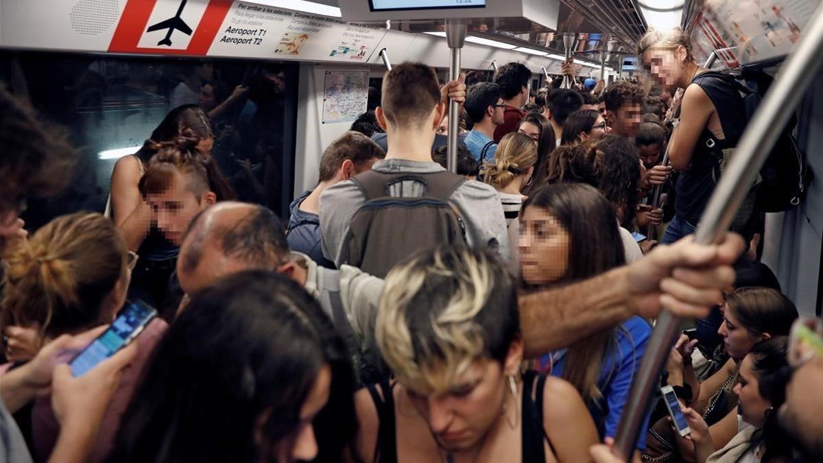 Centenares de personas se dirigen en metro al aeropuerto de El Prat, el 14 de octubre del 2019