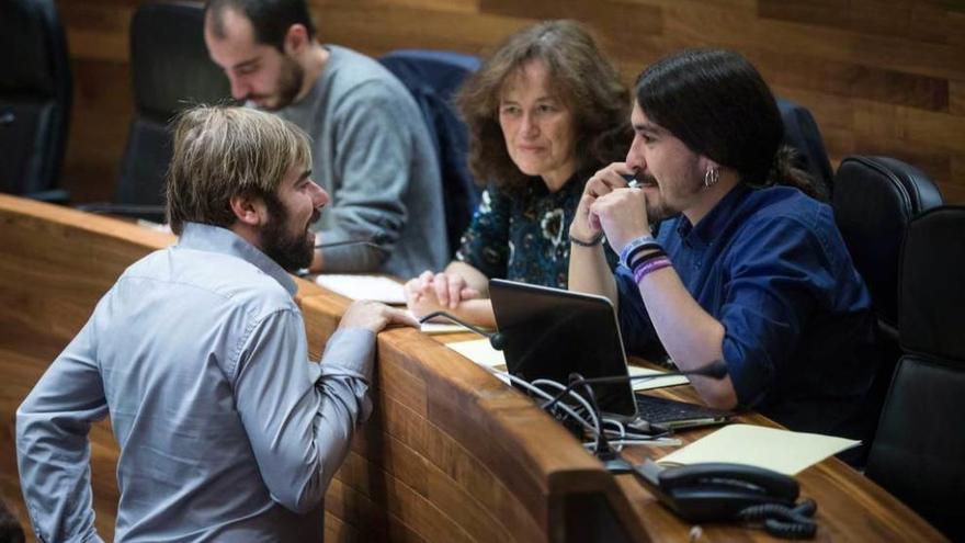 El diputado de Podemos Daniel Ripa (de pie) habla con sus compañeros Paula Valero y Andrés Fernández Vilanova, con Héctor Piernavieja al fondo.