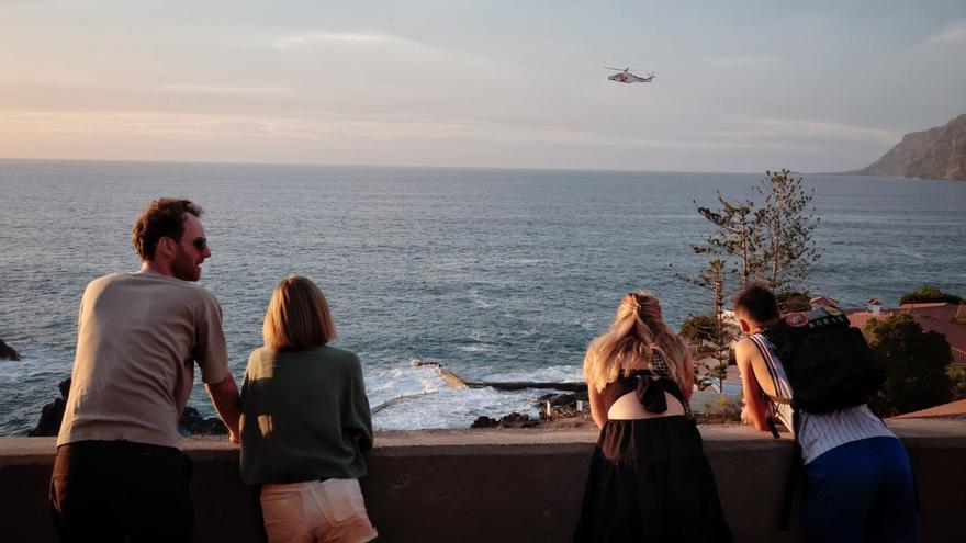 Turistas en Los Gigantes observan el helicóptero que busca al desaparecido en el charco de Isla Cangrejo. | MARÍA PISACA