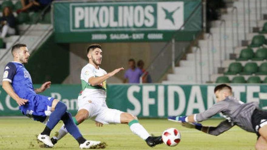 El portero del Córdoba se lanza para detener un balón cerca de su portería.