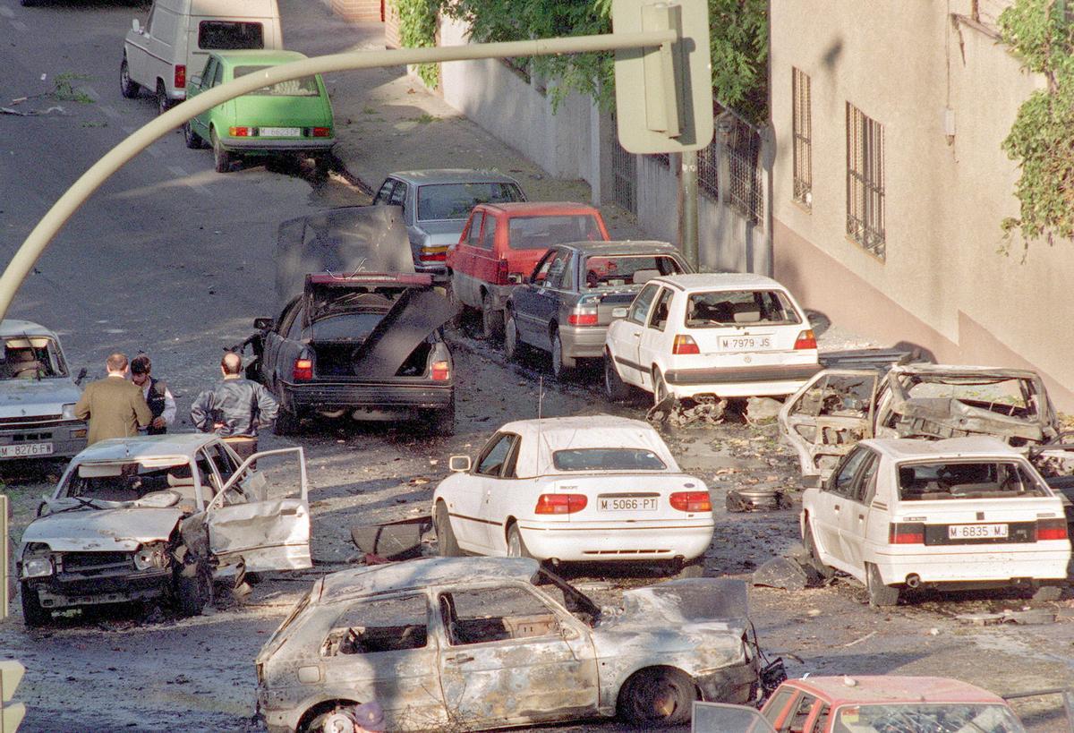 En el centro, oscuro, el coche en el que viajaba José María Aznar cuando sufrió el atentado de ETA que hizo estallar un coche bomba a su paso en 1995 en Madrid.