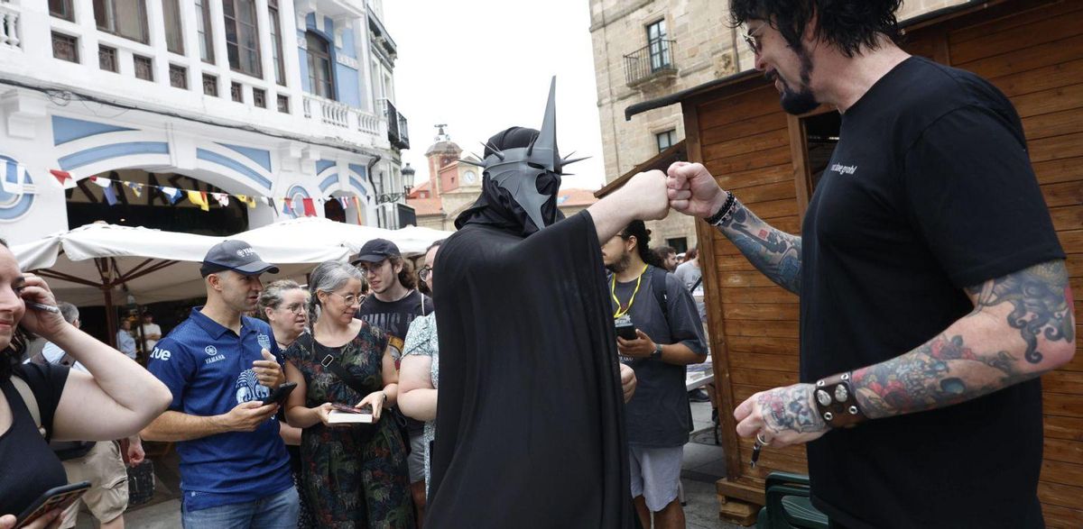 Jay Kristoff, a la derecha, saluda a uno de sus lectores más fanático al principio de una fila, en medio de la calle de San Francisco. | MIKI LÓPEZ