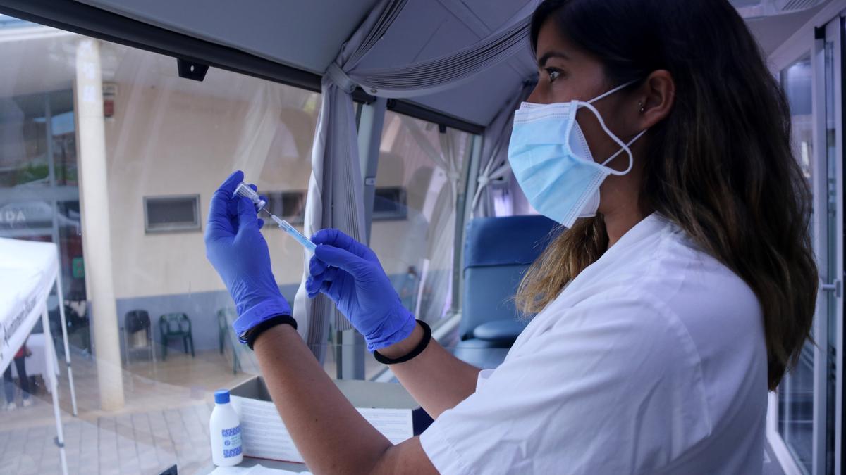 Pla mitjà d&#039;una infermera preparant una dosi de la vacuna Janssen a l&#039;interior del bus del Banc de Sang a Alcanar. Imatge del 7 de juliol de 2021. (Horitzontal)