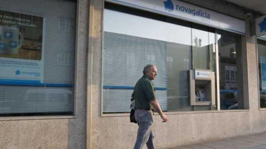 Un vecino de Lalín pasando ante una oficina de Novagalicia Banco.