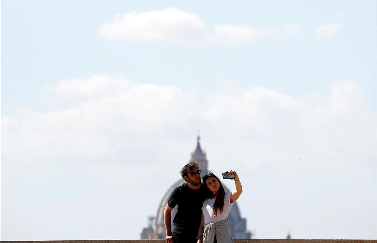 Una pareja en la terraza del Giardino degli Aranci (Jardín de los Naranjos) con la cúpula de San Pedro al fondo. 