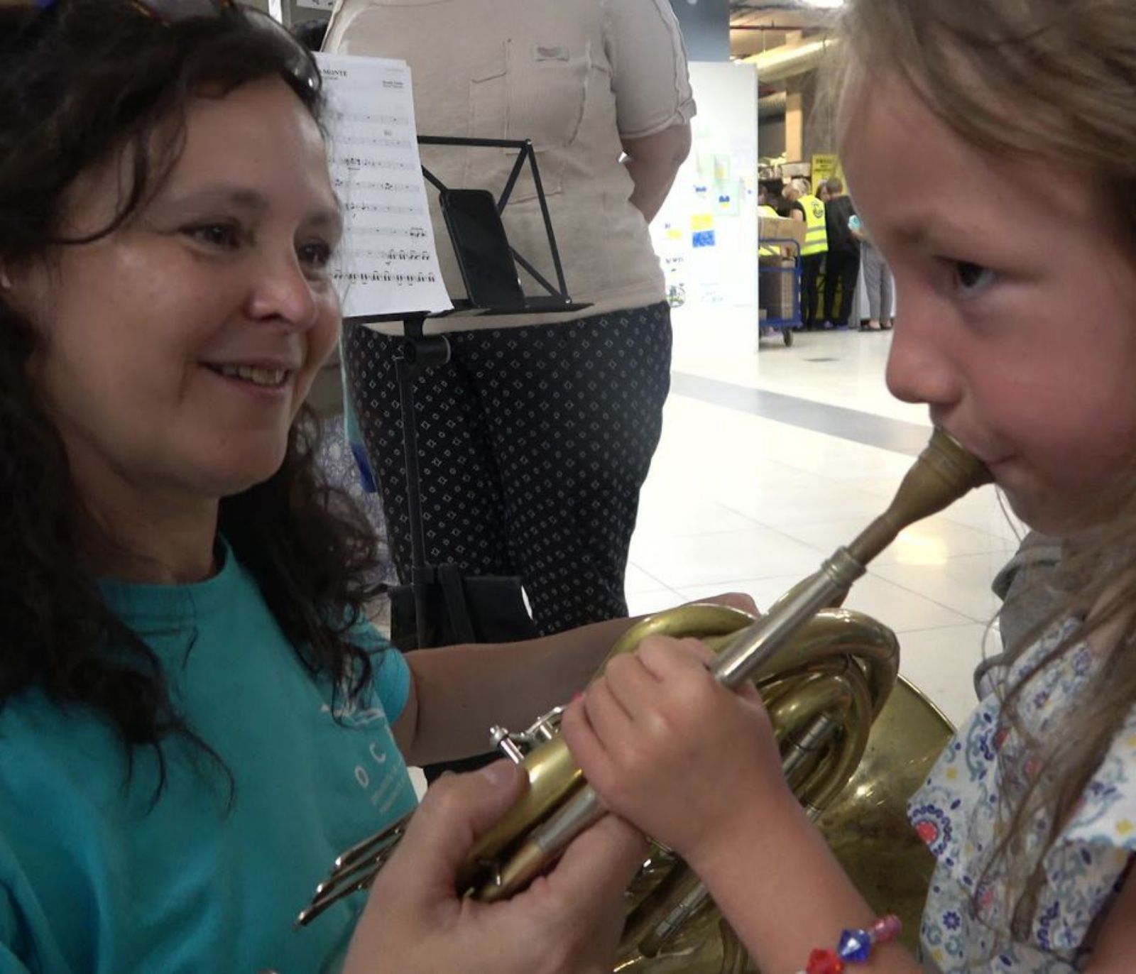 Una niña hace sonar la trompa de una de las instrumentistas de Siero. | OCAS