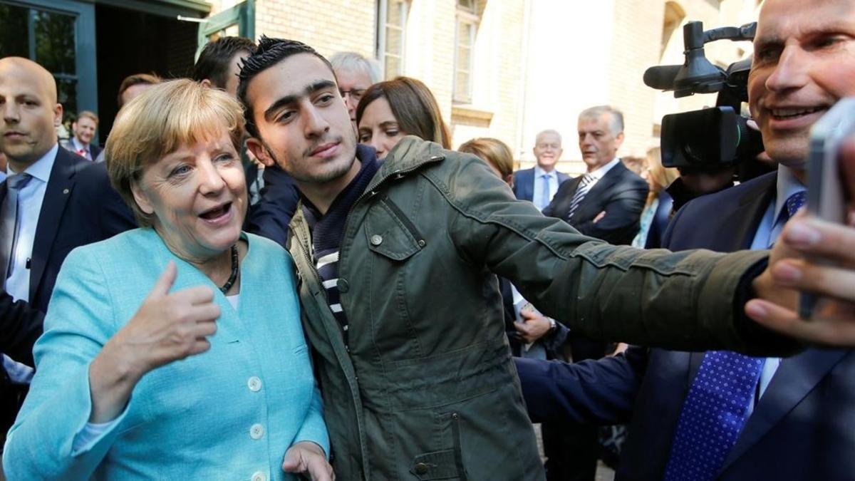 El refugiado sirio Anas M. se hace un selfie con Merkel, en septiembre del 2015