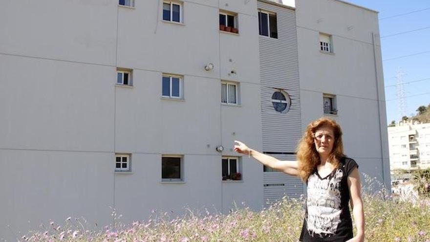 Carmen Ramírez, ayer, delante de la fachada de su edificio, con problemas de humedad en el tercer y el cuarto piso.