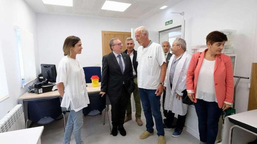 El consejero de Sanidad, Francisco del Busto, charla con el médico de Rioseco, Jesús Matos, en la reapertura del consultorio de Rioseco.