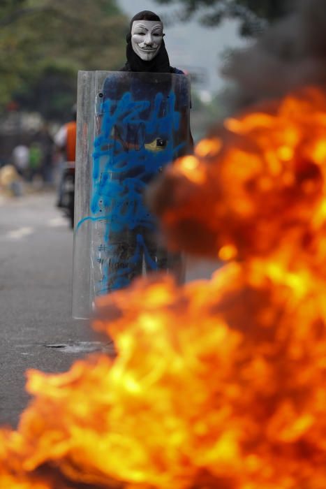 A demonstrator uses a riot police shield during ...