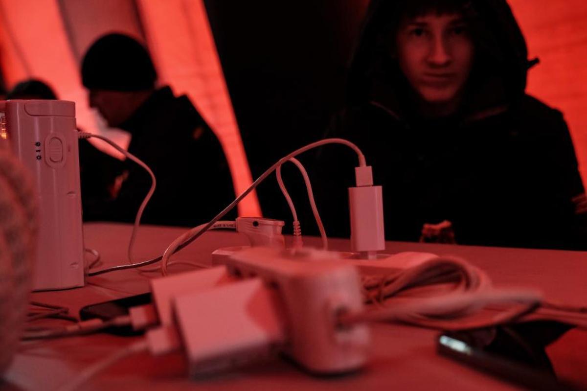 Ciudadanos ucranianos acuden a un generador callejero de electricidad para cargar sus móviles y ordenadores tras los ataques rusos contra infraestuctura de energía.