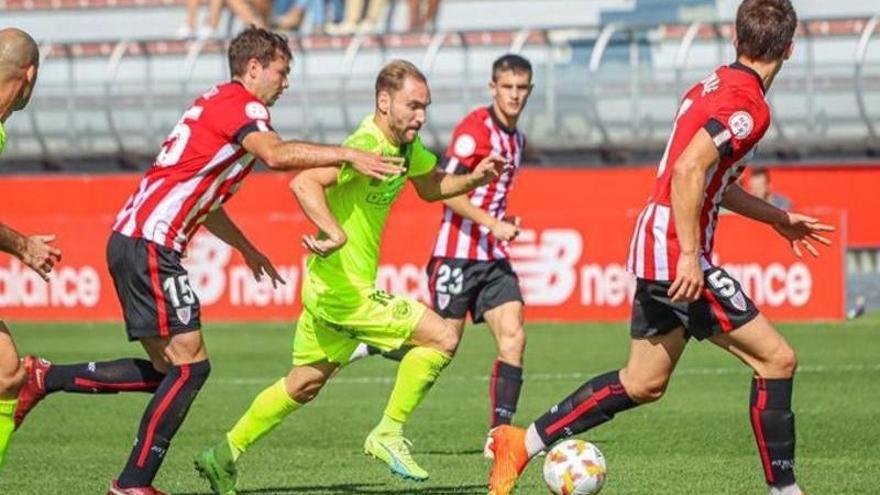 Cristian Herrera, rodeado de rivales, conduce la pelota en el campo de Lezama.