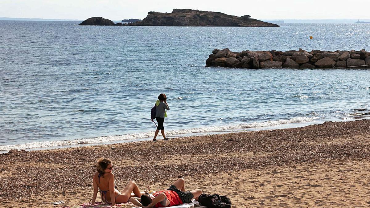 Dos personas tomando el sol en la playa de ses Figueretes el pasado noviembre. | VICENT MARÍ