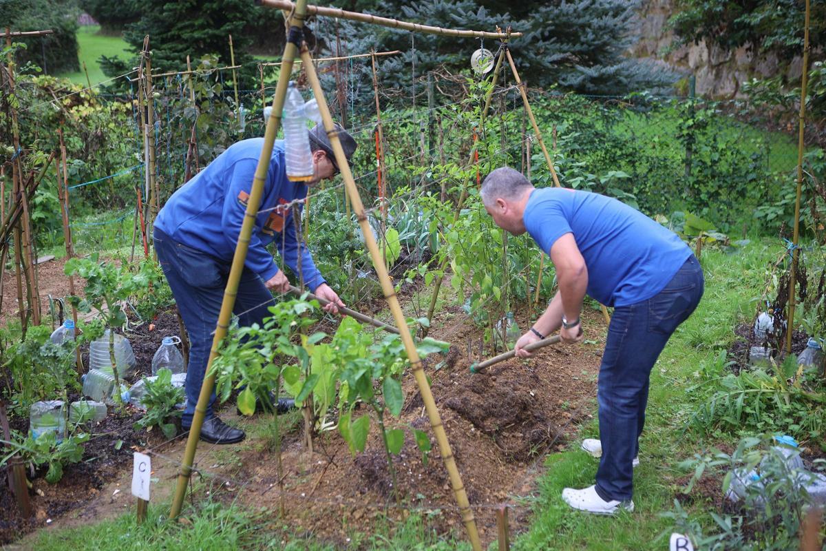 Dos vecinos trabajan en un huerto en Galicia.