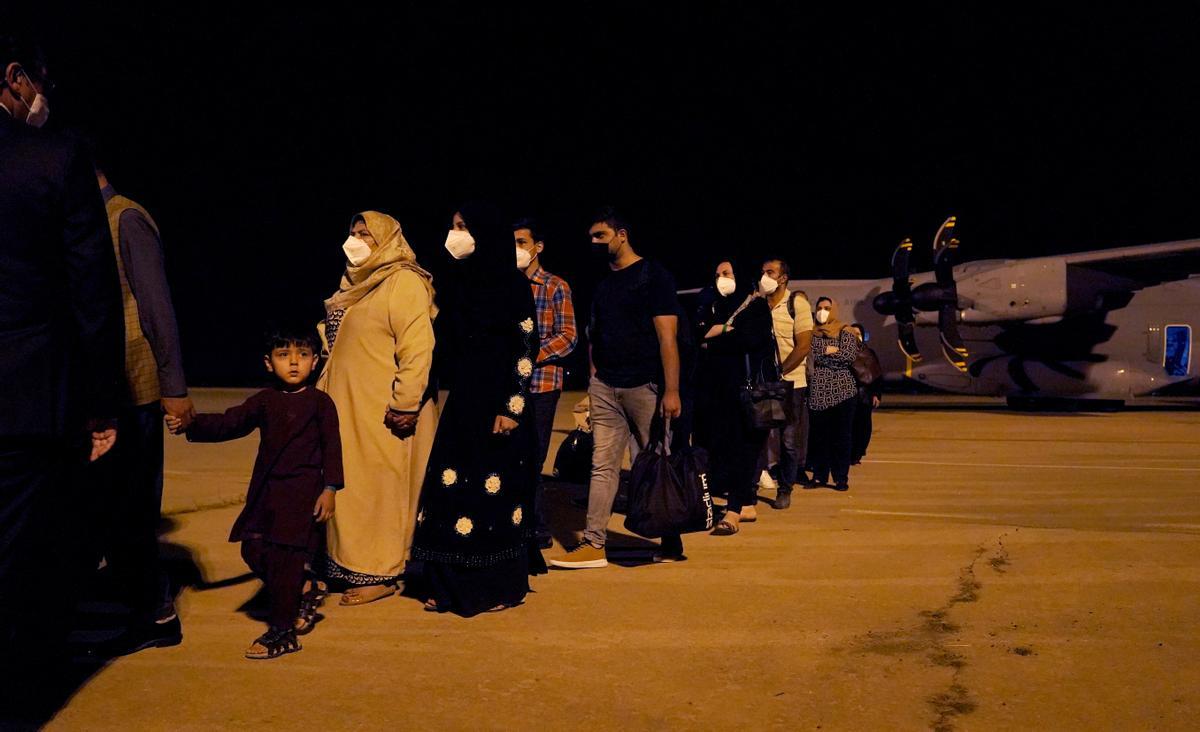 Con muy escasos enseres bajan a la pista de la base aérea de Torrejón los recién llegados. 