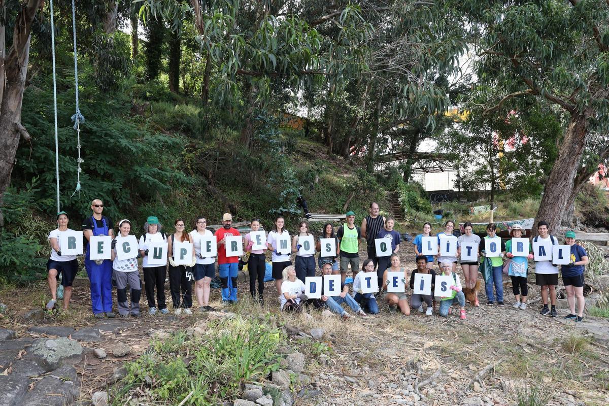 Los voluntarios posan con un mensaje reivindicativo por la recuperación del litoral de Teis