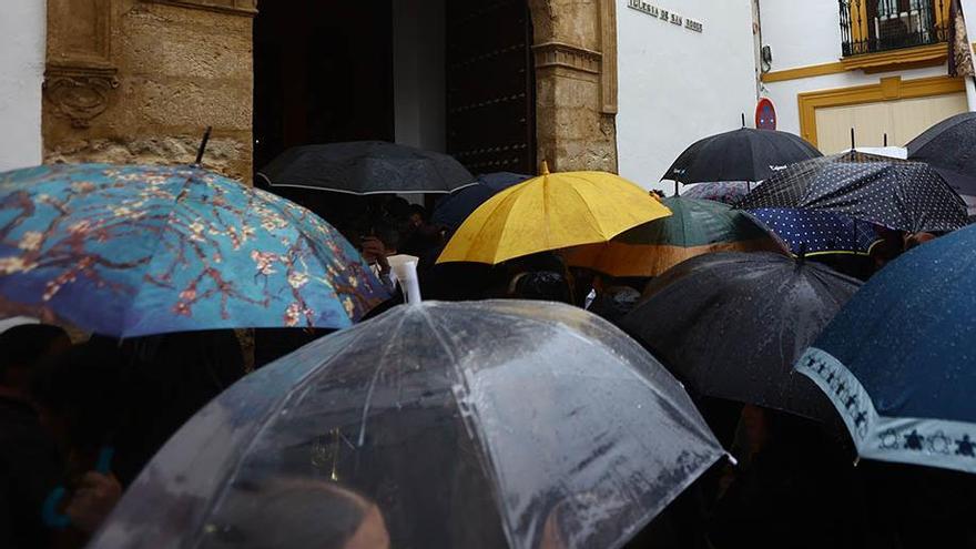 Paraguas ante la puerta de San Roque, a la espera de la salida de la procesión de El Perdón, el Miércoles Santo en Córdoba.