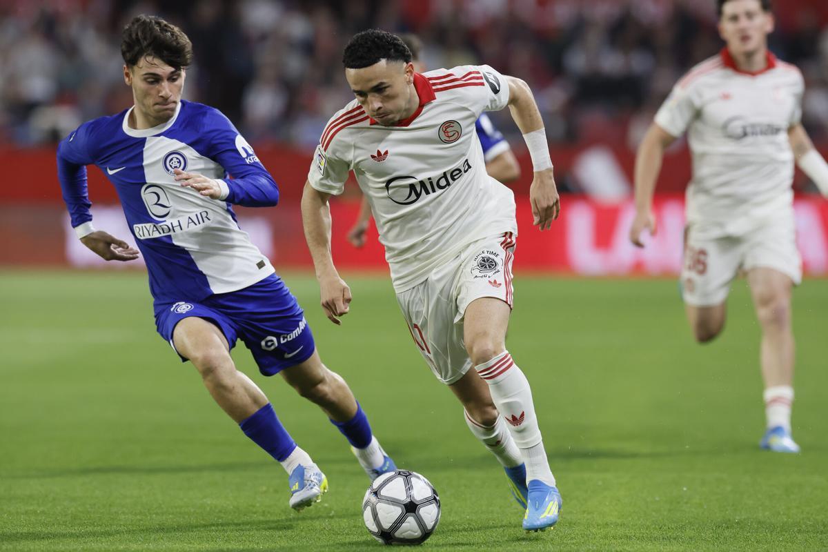El centrocampista del Sevilla Rubén Vargas juega un balón ante Rodrigo Mendoza, del Atlético, durante el partido de LaLiga de fútbol que Sevilla FC y Atlético de Madrid disputan en el estadio Ramón Sánchez-Pizjuán
