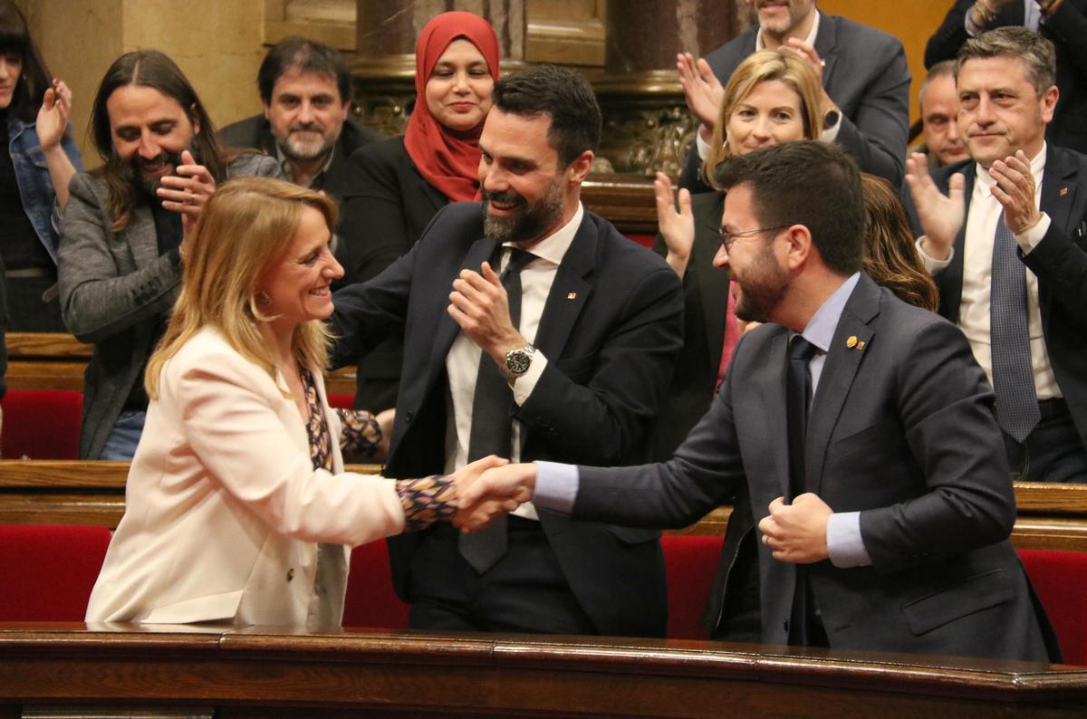 Pere Aragonès, encaixa la mà de la consellera d'Economia, Natàlia Mas, al costat del conseller Roger Torrent, després de l'aprovació dels pressupostos al Parlament l'any 2023