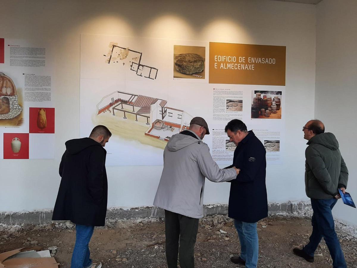 Félix Juncal y Román Rodríguez conversan ayer en la sala del “Bueu Romano” ante uno de los paneles interpretativos.