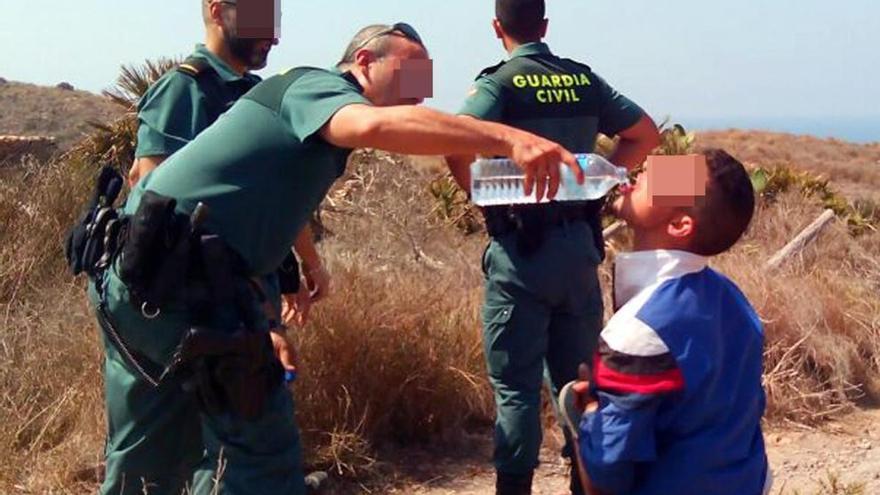 Un miembro de la Guardia Civil da de beber a un inmigrante exhausto