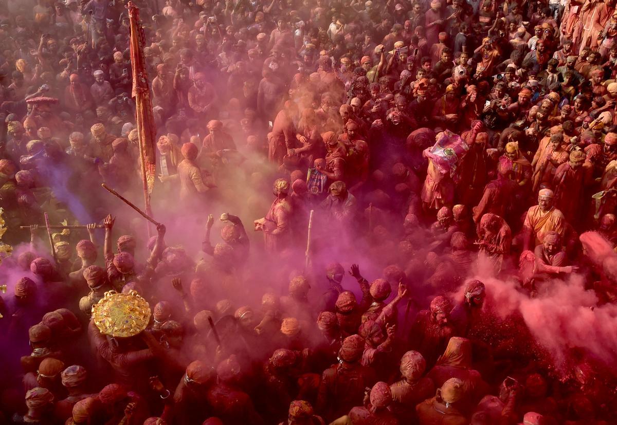 Los devotos hindúes participan en el festival religioso de Holi dentro de un templo en la aldea de Nandgaon, en el estado de Uttar Pradesh, India.