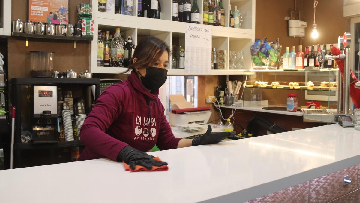 Pla mitjà d'una cambrera netejant la barra del bar Ca la Meri de Tarragona, just abans del tancament del matí a dos quarts d'onze. Foto del 8 de febrer del 2020