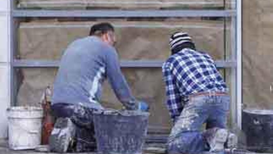 Operarios trabajan en la puesta a punto de un local comercial en la capital.