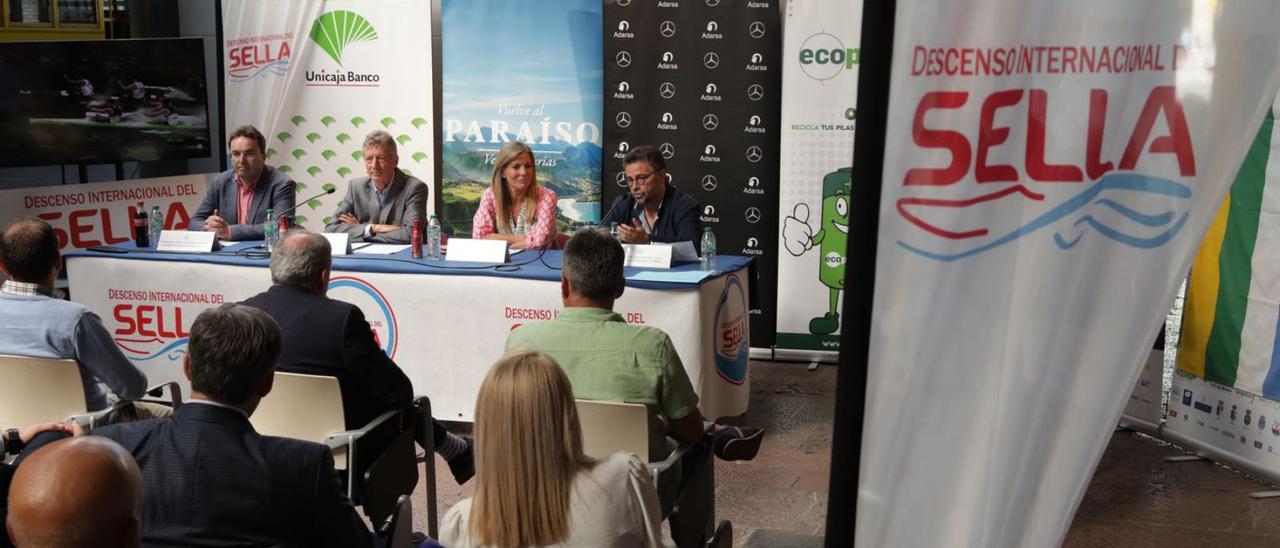 En la mesa, por la izquierda, Ángel Vallina, Juan Manuel Feliz, Graciela Blanco y Mariano Santiso. En el círculo, Alexander Shaparenko, junto al cartel de la 84ª edición del Descenso del Sella. | Juan Plaza / Á. C.