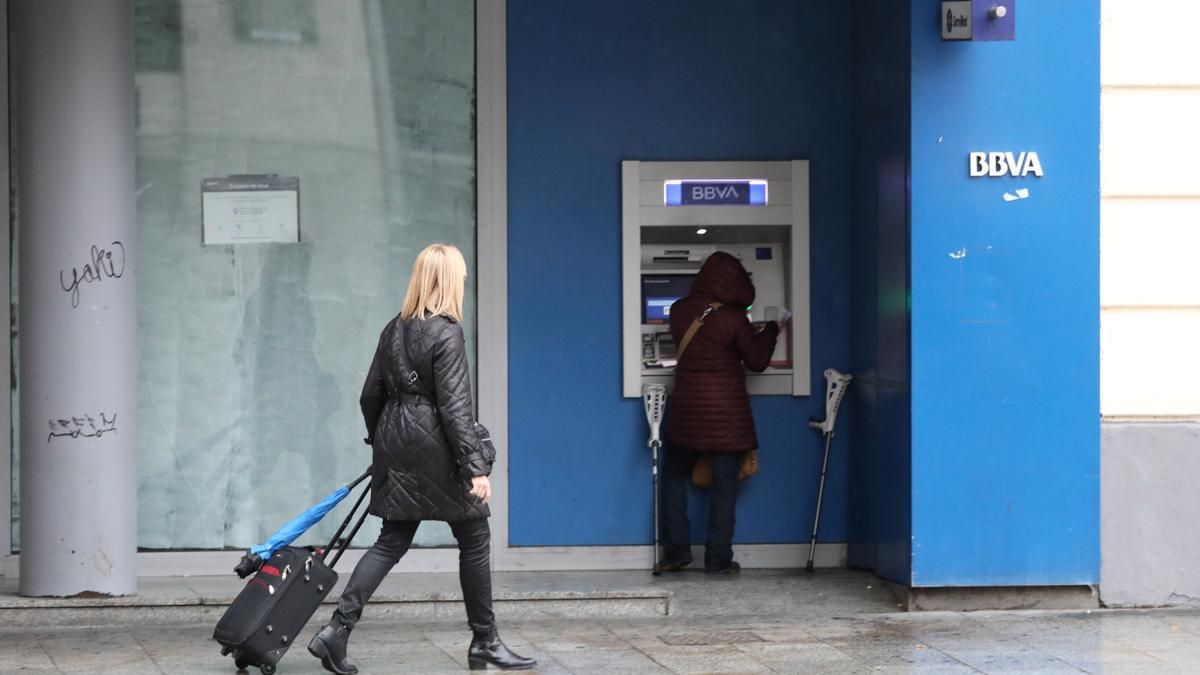 Una mujer saca dinero en un cajero automático de una oficina bancaria de Zaragoza.