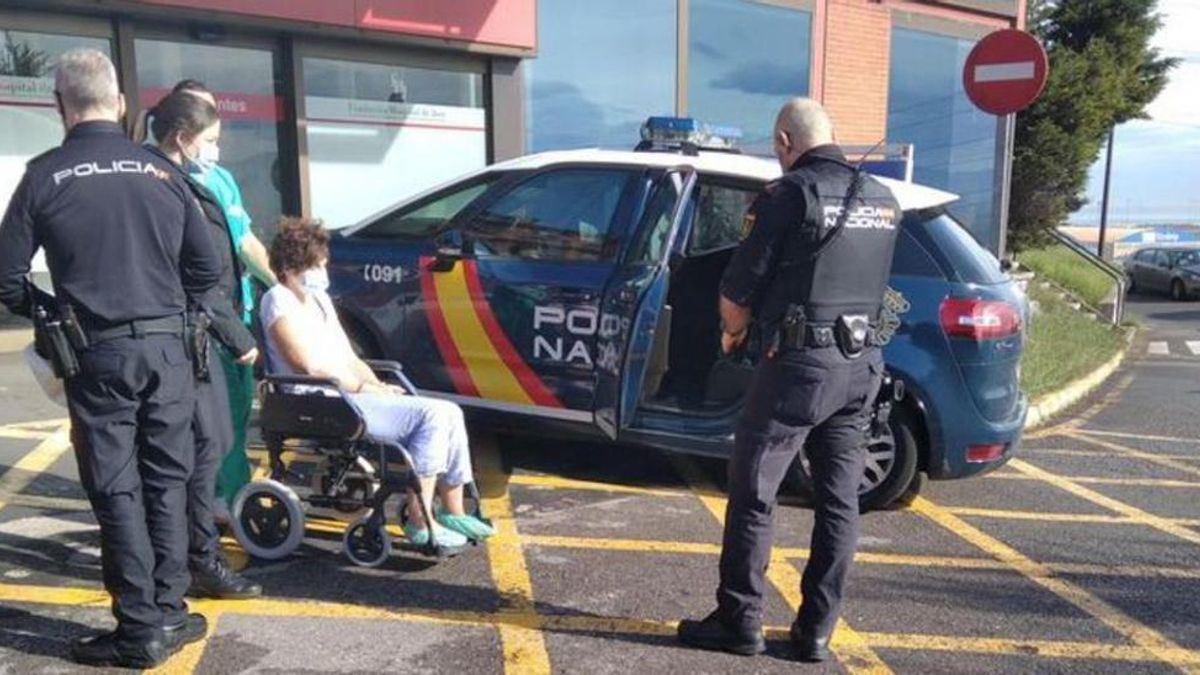 Agentes de la Policía Nacional custodian a la parricida a su salida del Hospital de Jove, el lunes.