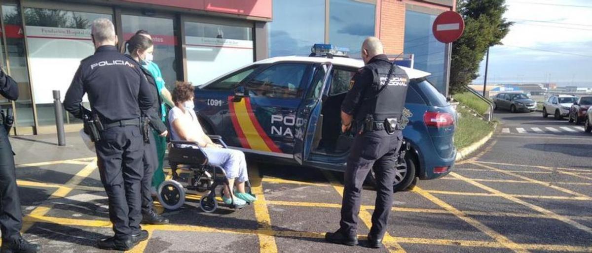 Agentes de la Policía Nacional custodian a la parricida a su salida del Hospital de Jove, el lunes.