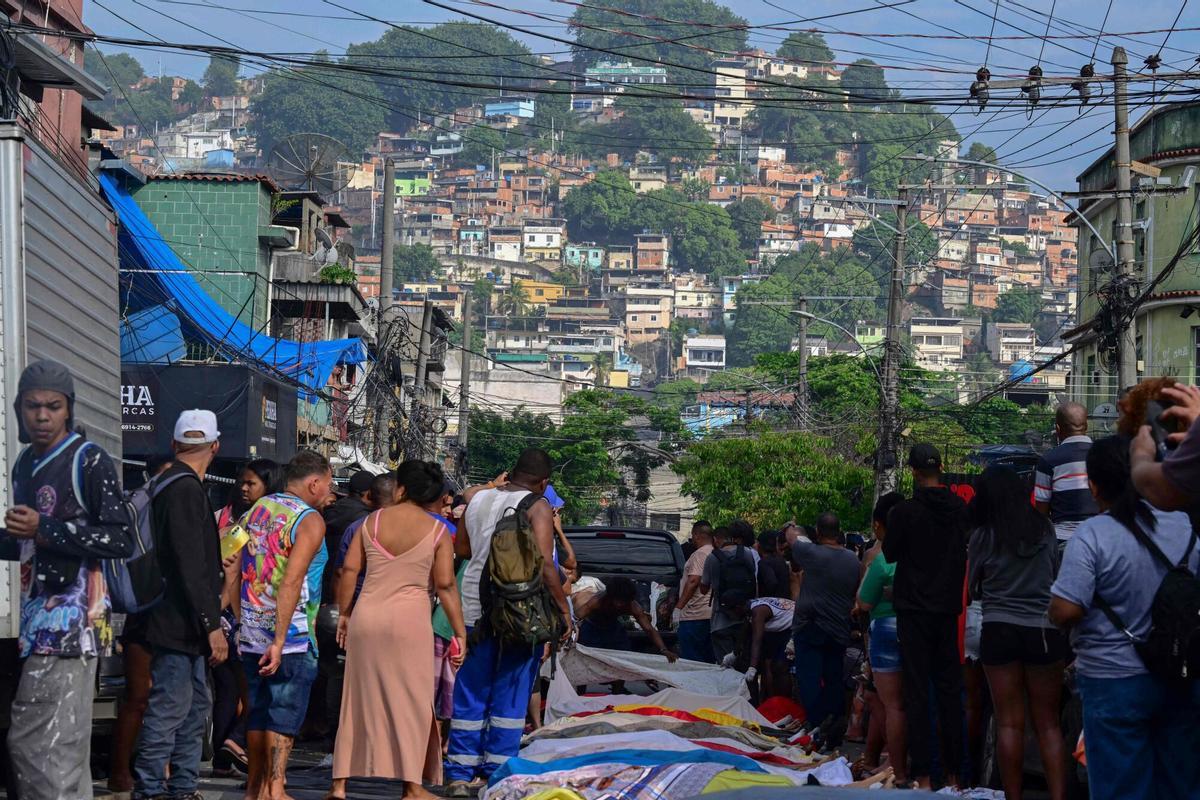 EDITORS NOTE: Graphic content / Bodies are seen lined up on Sao Lucas Square of the Vila Cruzeiro favela at the Penha complex in Rio de Janeiro, Brazil, on October 29, 2025, in the aftermath of Operacao Contencao (Operation Containment). Bodies piled up in poor neighborhoods of Rio de Janeiro on October 28 as police launched their biggest ever raids on the citys drug traffickers, leaving at least 64 dead in war-like scenes. As many as 2,500 heavily armed officers, backed by armored vehicles, helicopters and drones took part in the operation targeting Brazils main drug-trafficking gang in two poor neighborhoods, or favelas, in northern Rio. (Photo by Pablo PORCIUNCULA / AFP). Graphic content