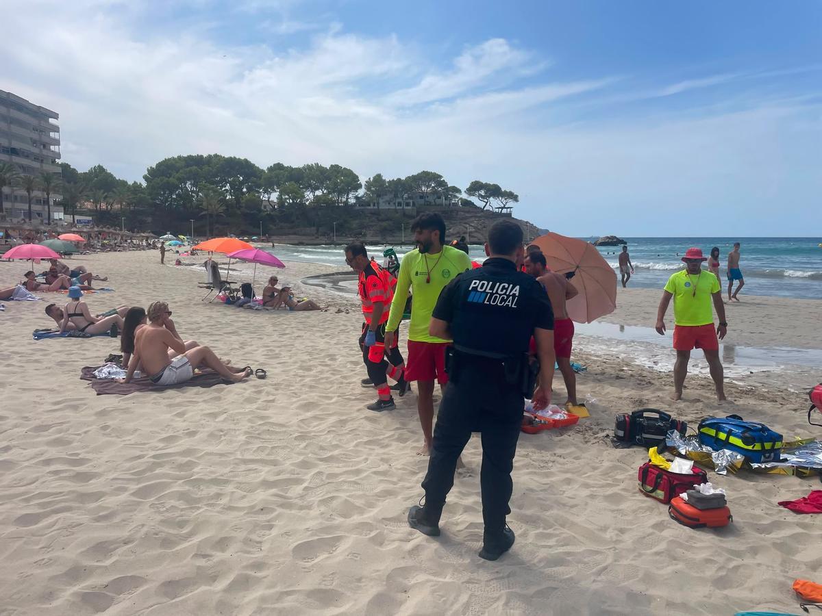 Socorristas, sanitarios y policías locales de Calvià durante la asistencia en Peguera al turista portugués con sintomas de ahogamiento.