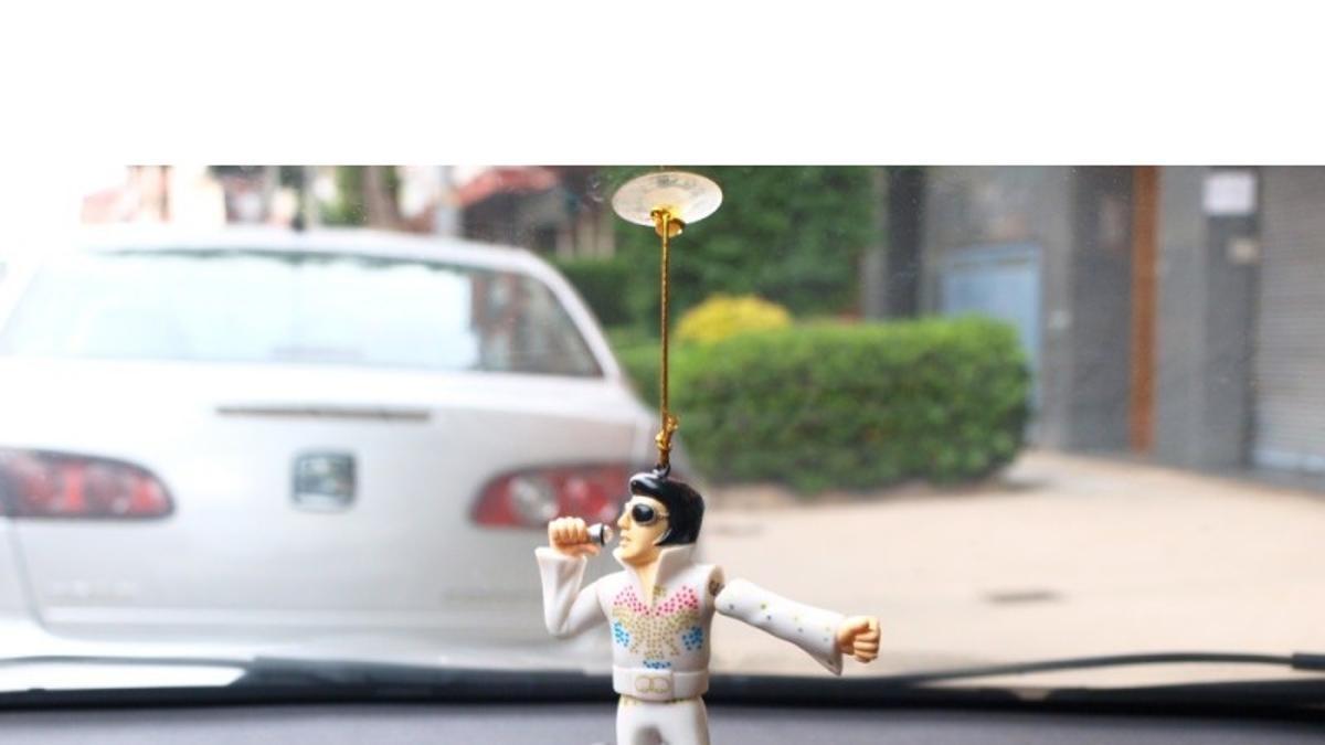 Un muñeco de Elvis Presley en un coche.