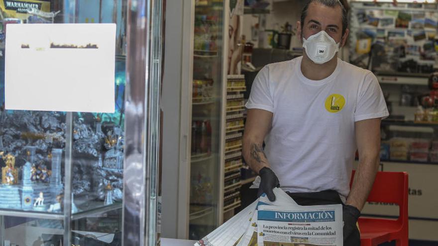 Un vendedor de prensa en Elche, protegido con mascarilla durante el desempeño de su actividad laboral.