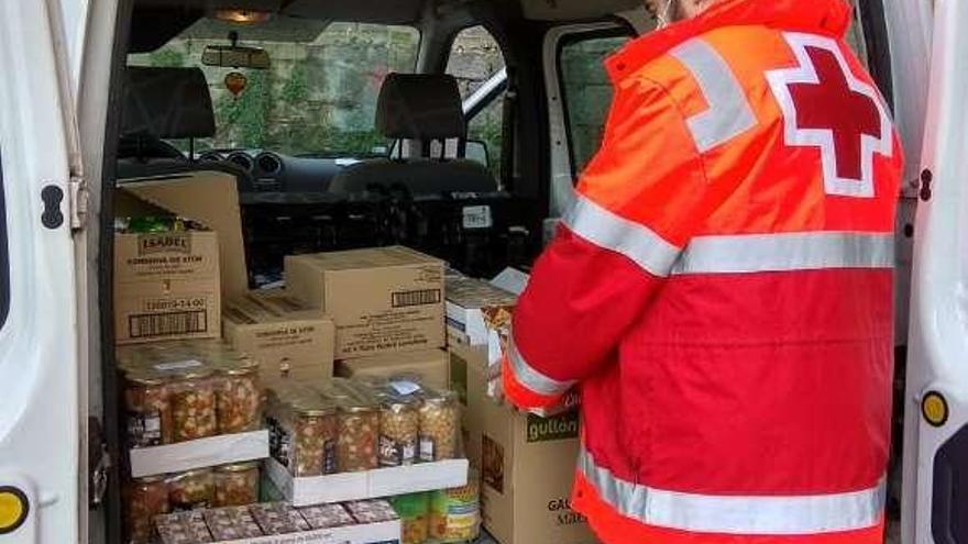 Uno de los voluntarios de Cruz Roja, con comida que se va a repartir.