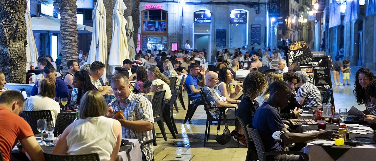 Las terrazas se llenan de día y de noche sobre todo en ciudades costeras. En la imagen, ambiente un día laborable de esta semana en las proximidades del Ayuntamiento de Alicante. | RAFA ARJONES