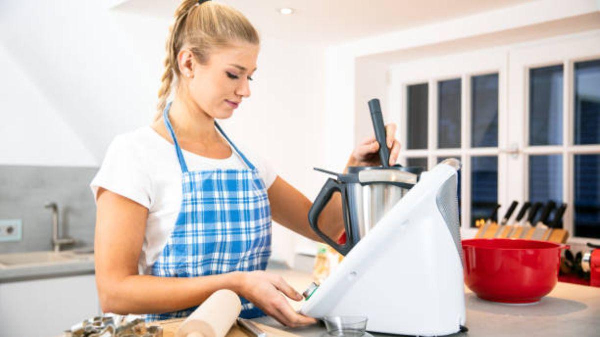 Una mujer usando un robot de cocina